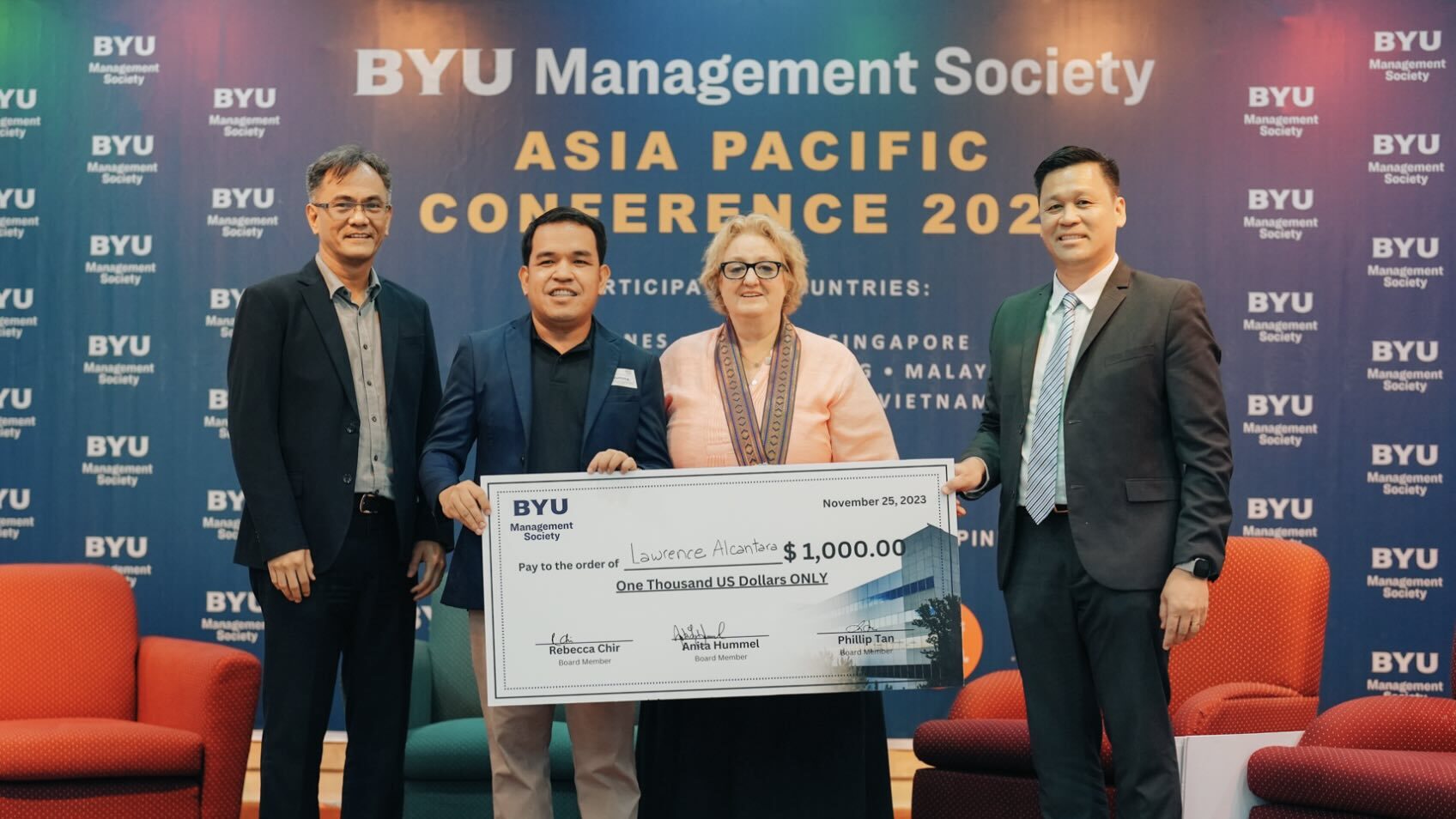 Lawrence A. Alcantara holding an award with Philip Tan (on the right), Anita Hummel (in the middle), and G. Kenneth Lee (on the left side).